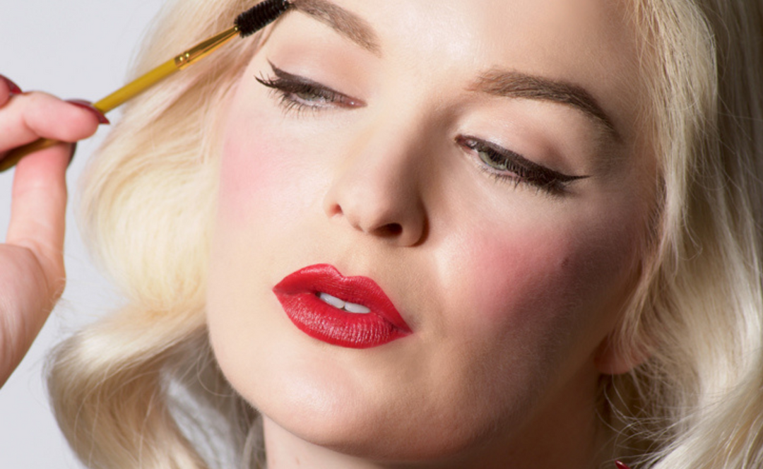 Woman applying Bésame Cosmetics Cake Mascara on eyebrows