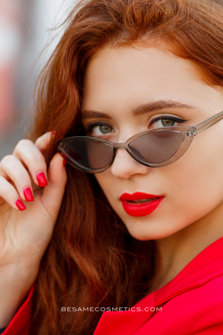 Red hair woman wearing red nail polish and red lipstick